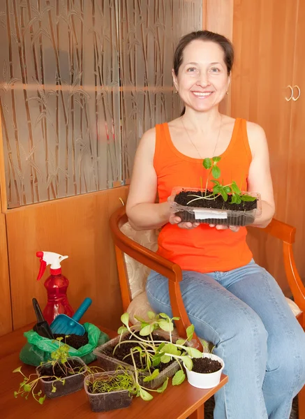 Mogen kvinna med olika plantor — Stockfoto
