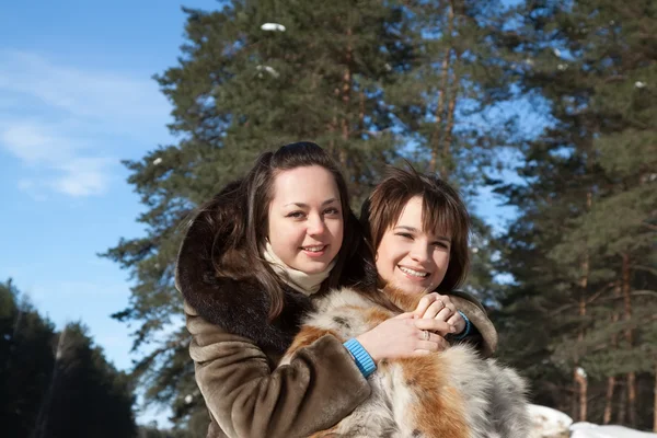 Две улыбающиеся девушки зимой — стоковое фото