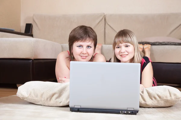 Meninas deitadas no chão e usando laptop — Fotografia de Stock