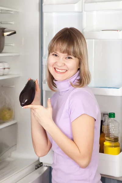 Kvinna med äggplanta från kylskåp — Stockfoto