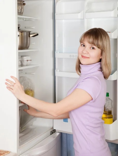 Vrouw op zoek naar iets in de koelkast — Stockfoto