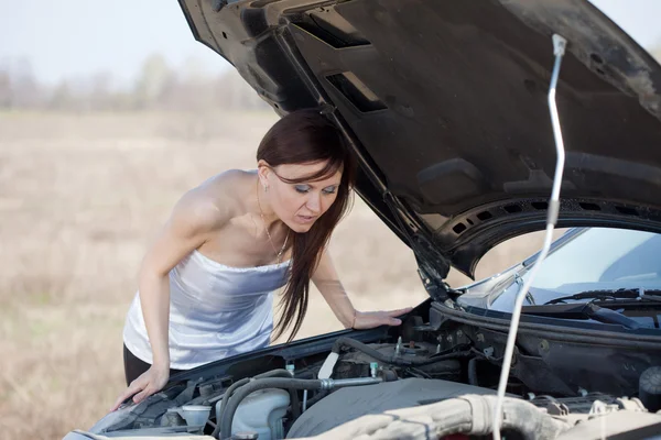 Женщина чинит свою машину — стоковое фото