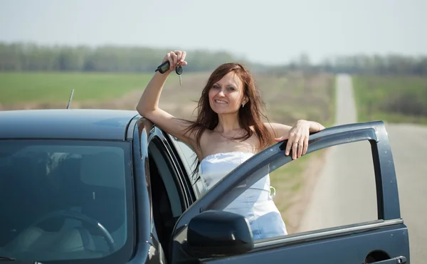 Woman holding keys to new car — Stock Photo, Image