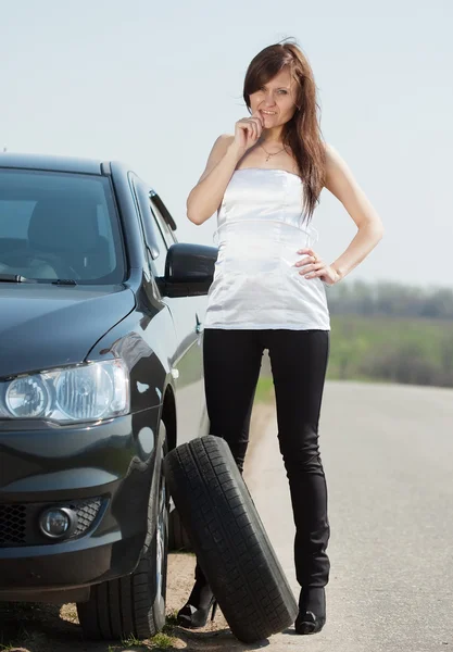 Woman changing car wheel Stock Picture