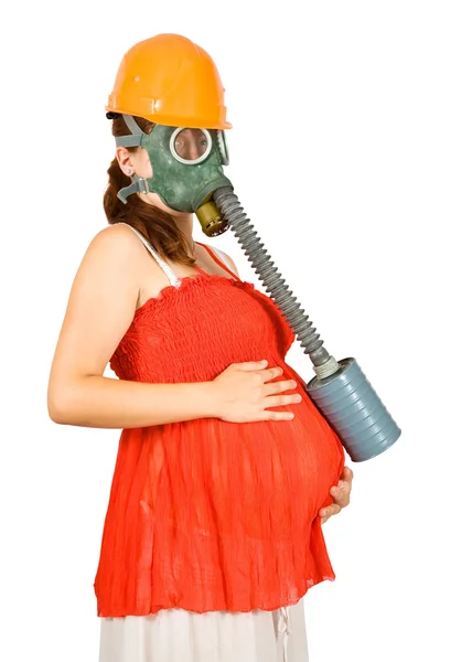 Žena v bezpečnostní přilba a plynovou masku drží těhotné bříško — Stock fotografie