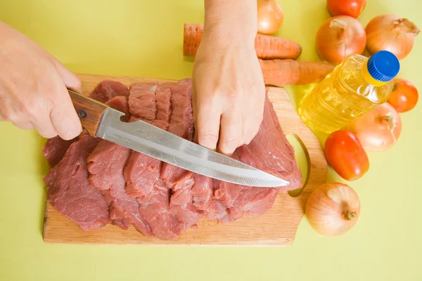 Cook hands cutting beef on cutting board — Stock Photo, Image