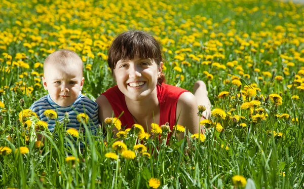 タンポポの草原で赤ちゃんと母 — ストック写真