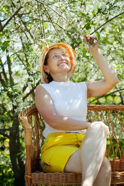 Зрелая женщина в цветущем саду — стоковое фото
