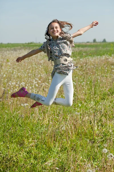 Happy teenager girl jumps at meadow — Stock Photo, Image
