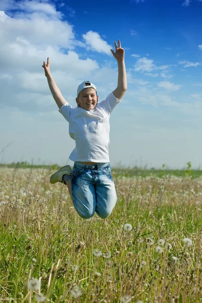 Glücklicher Teenager springt auf Wiese — Stockfoto
