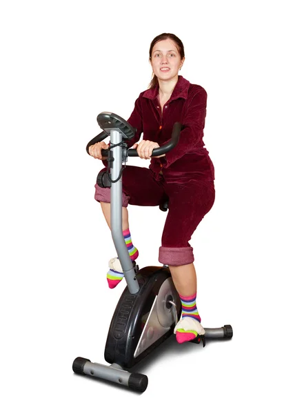 Dziewczyna ćwiczenia na rower treningowy na białym tle — Zdjęcie stockowe