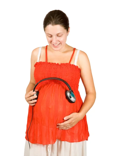 Mulher grávida com fones de ouvido na barriga — Fotografia de Stock