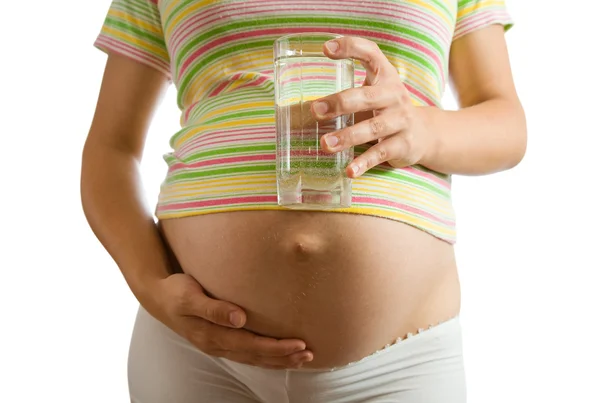 Беременная женщина со стаканом воды — стоковое фото