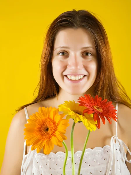 Chica con flores sobre amarillo —  Fotos de Stock