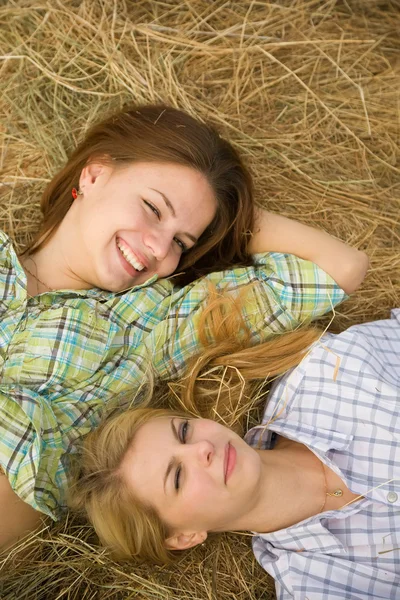 Девушки отдыхают на тюке сена — стоковое фото