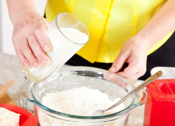 stock image Cook hands pouring milk into dough