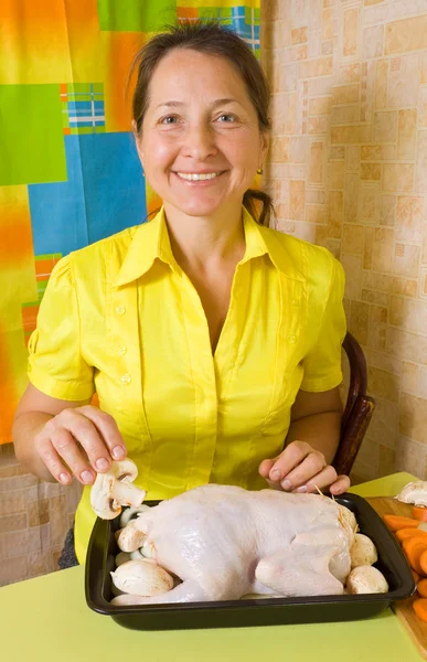 Woman adds mushrooms to stuffed chicken — Stock Photo, Image