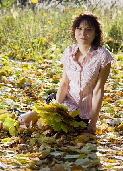 Девушка сидит в осеннем парке — стоковое фото