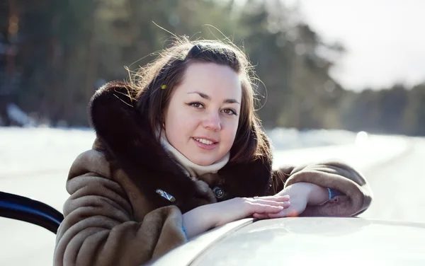 Mulher perto de seu carro na estrada de inverno — Fotografia de Stock