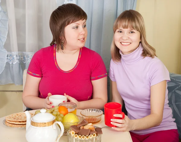 Flickor dricka te och skvallra i hem — Stockfoto