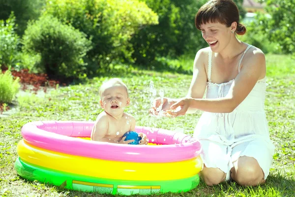Glad baby svømning i oppustelig pool - Stock-foto