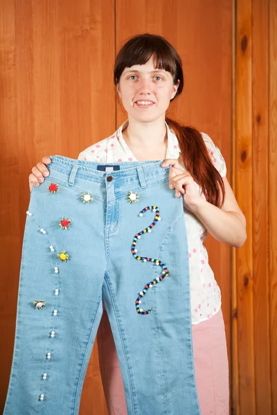 Woman shows jeans beaded by herself — Stock Photo, Image