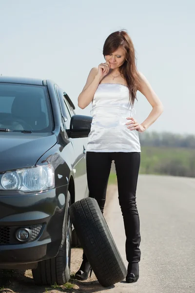 Woman changing car wheel — Stock Photo, Image