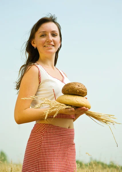 Jente med brød på åkeren – stockfoto