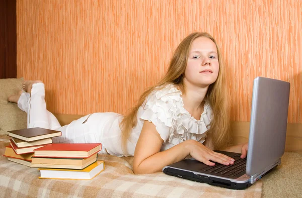 Flicka med bärbar dator och böcker — Stockfoto