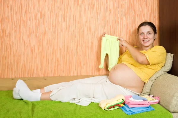 Έγκυος γυναίκα με ρούχα του μωρού — Φωτογραφία Αρχείου