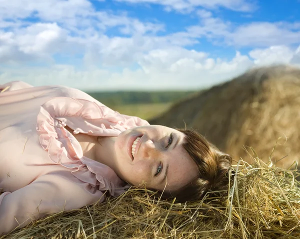 Girl laying on hay bail — Stock Photo, Image