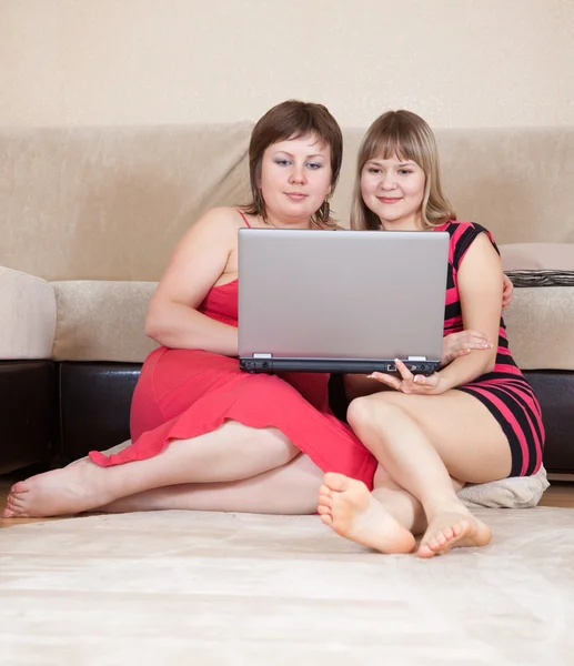 Две женщины, использующие ноутбук дома — стоковое фото
