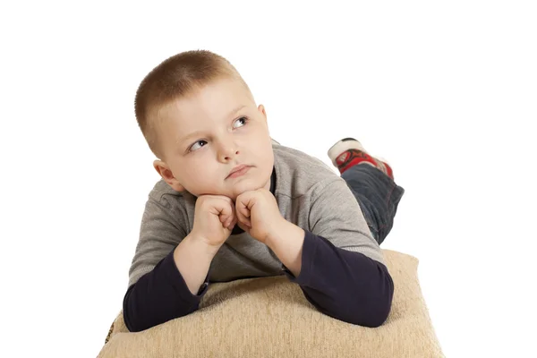 Malý chlapec dát lokty na polštář — Stock fotografie