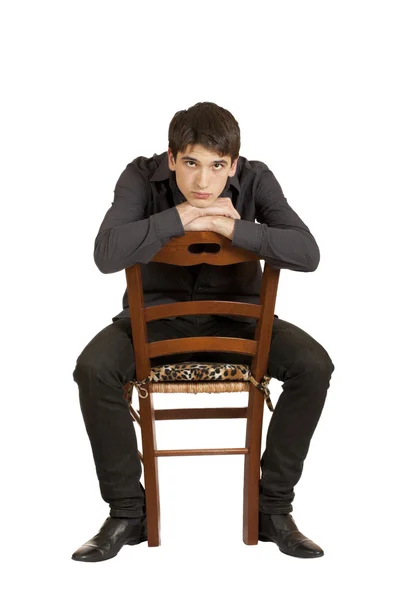 年轻男子坐在一张椅子上 — 图库照片