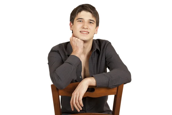 Νεαρός άνδρας κάθεται σε μια καρέκλα — Φωτογραφία Αρχείου