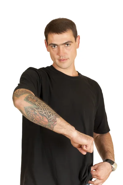 Pohledný mladý muž ukazuje tetování na rameno — Stock fotografie