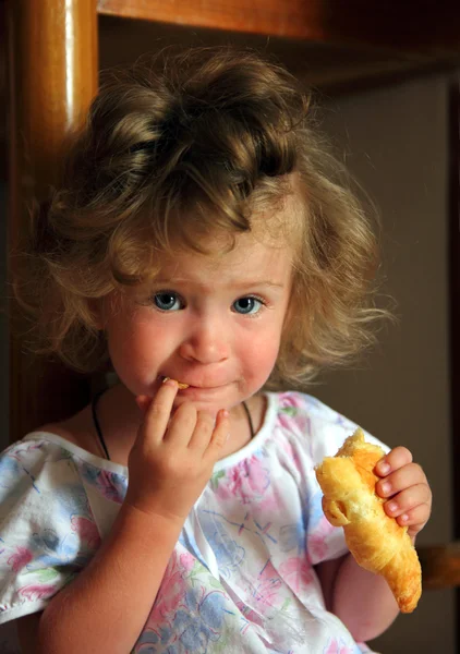 Μικρό κορίτσι τρώει κρουασάν — Φωτογραφία Αρχείου