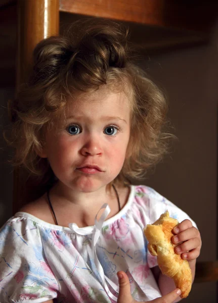 Malá dívka jíst rohlík — Stock fotografie