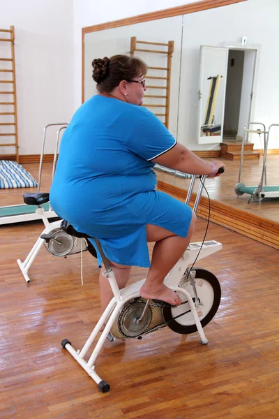 骑自行车锻炼的超重妇女 — 图库照片