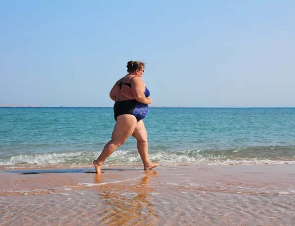 运行在海滩上的胖女人 — 图库照片