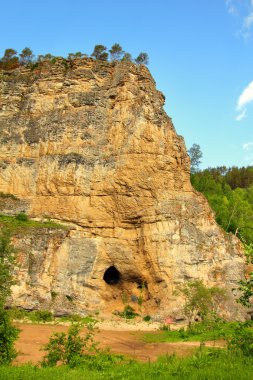 Kalimoskan rock with cave in southern Ural clipart