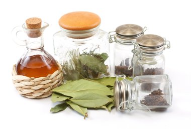 Vinegar bottle, spices and laurel leaf on the white clipart