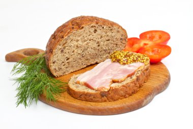 Bread with ham, mustard, dill and tomato on the wood plate clipart