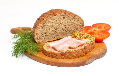 Bread with ham, mustard, dill and tomato on the wood plate clipart