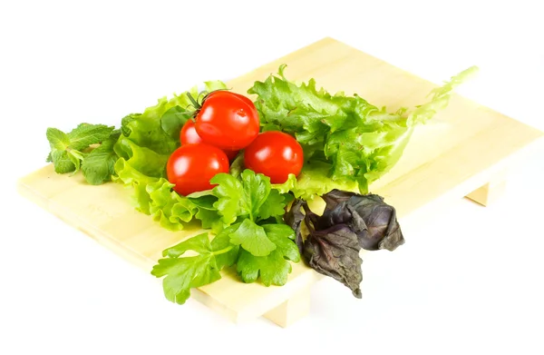 Свежие и сочные овощи на деревянной пластине изолированы — стоковое фото
