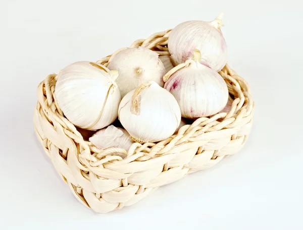 stock image Several garlic onions in a basket isolated