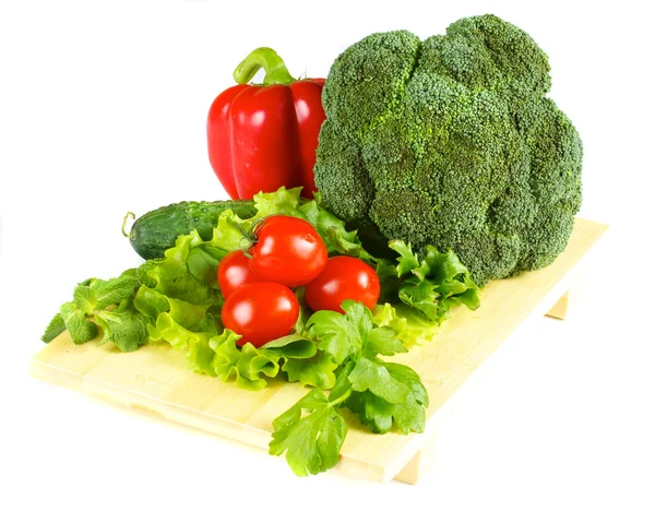 Čerstvé a šťavnaté zeleniny na dřevěné desce izolované — Stock fotografie