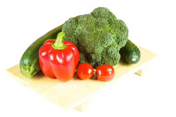 Verduras frescas y jugosas en el plato de madera aisladas — Foto de Stock