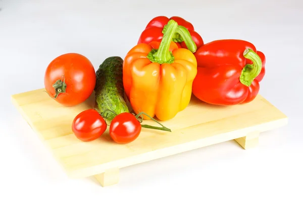 Verdure fresche e succose sul piatto di legno isolato — Foto Stock