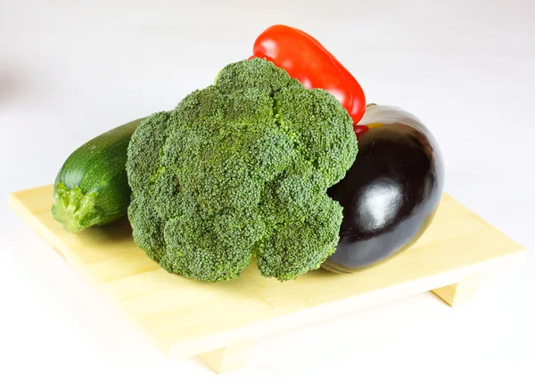 Verduras frescas y jugosas en el plato de madera aisladas — Foto de Stock